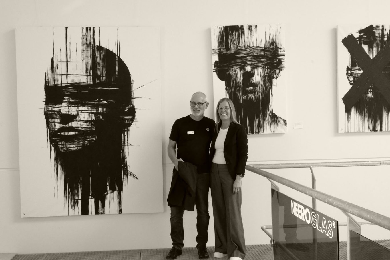 Exhibited at Gutshofgalerie bei KASIGLAS®, Bardowick Andreas und Britta Rixgens vor abstrakten Schwarz-Weiß-Gemälden mit menschlichen Gesichtern.
